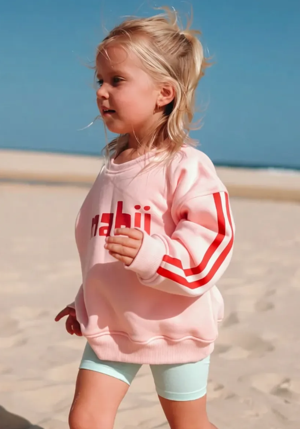 Child wearing a pink jumper with two red stripes and red Mabii logo